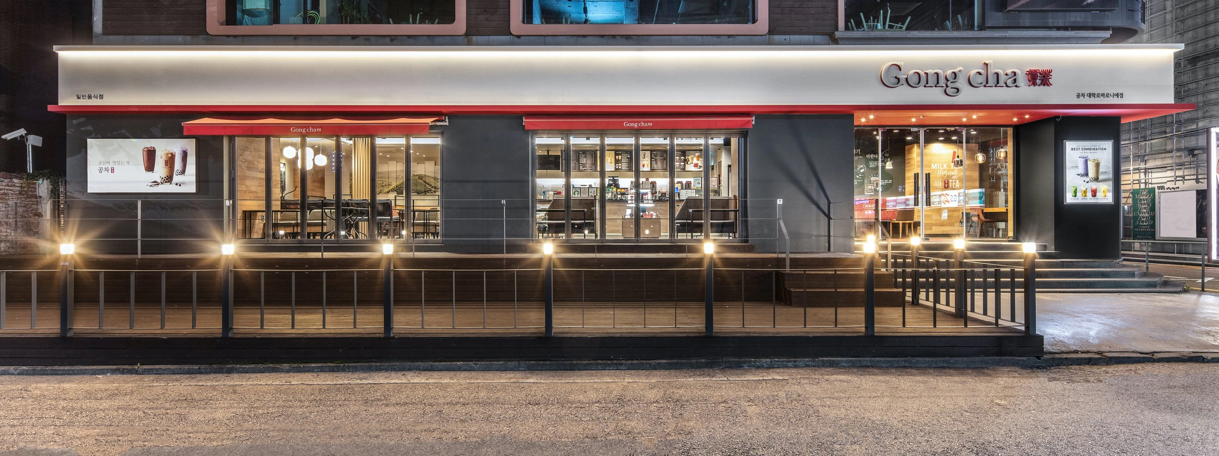 Storefront exterior at night with Tea Red awning