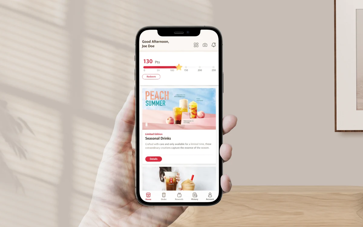 Gong cha ordering app home screen &mdash; points balance and seasonal drinks &mdash; held in one hand